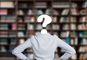 大学生在图书馆使用大学生在线平台备考考研，笔记本电脑屏幕显示考研政治框架，暖光氛围